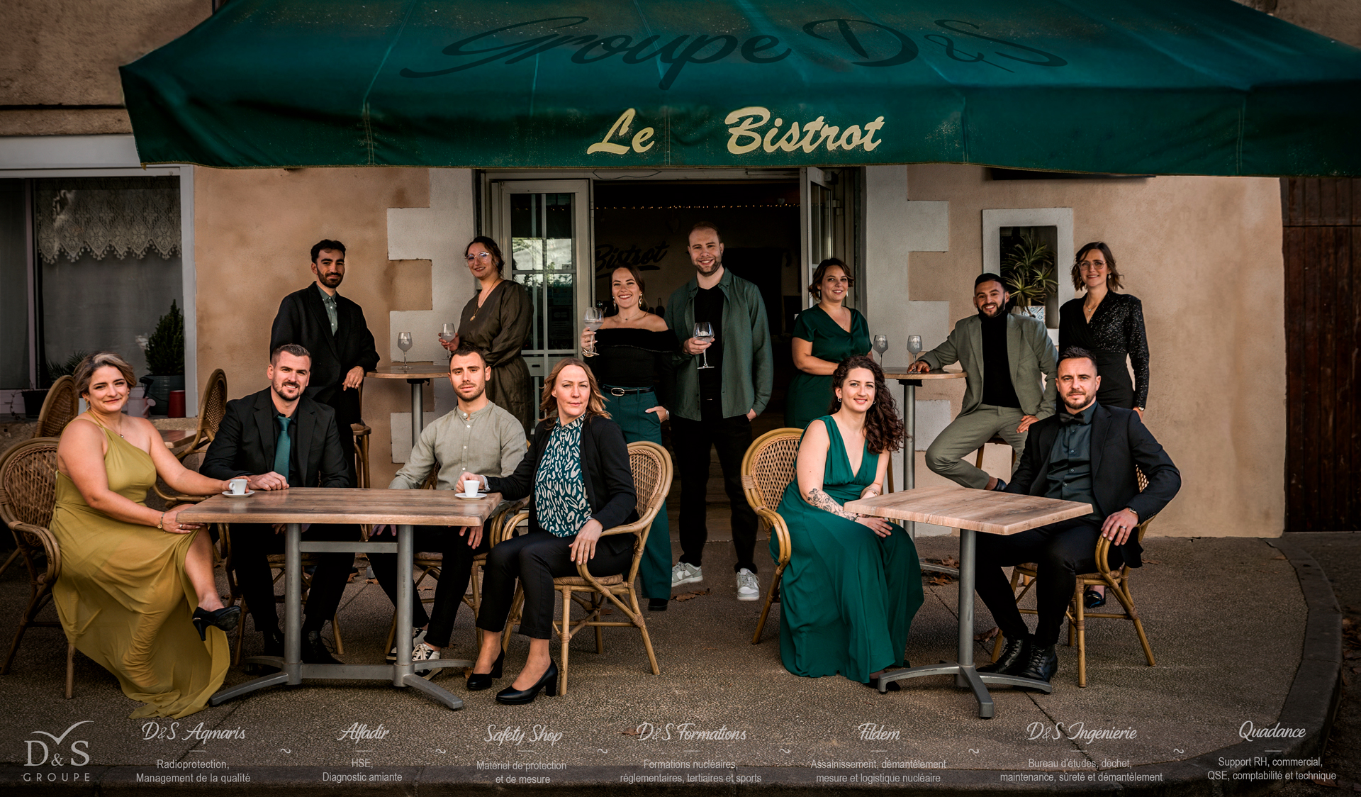 13 collaborateurs et collaboratrices prennent la pose à la terrasse d'un bistrot provençal pour vous souhaiter une bonne année 2026 !